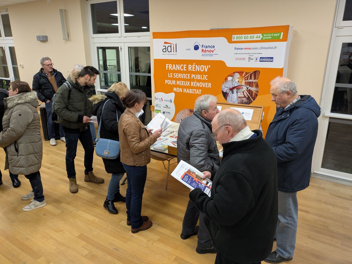 Photo du salon sur laquelle figure des personnes devant le stand de l'ADIL 57